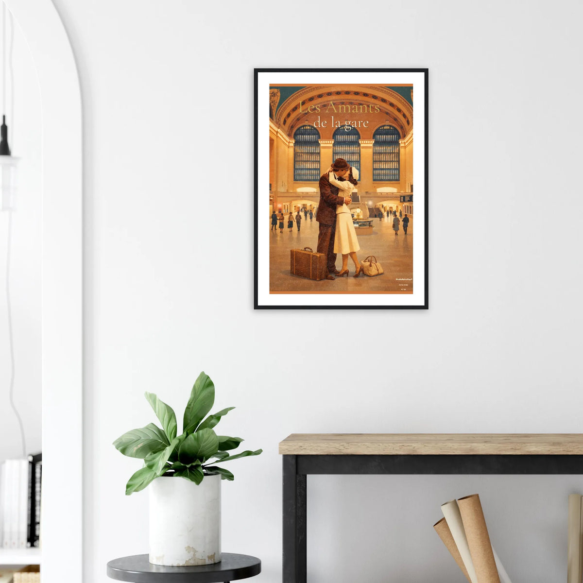 	Affiche rétro « Les Amants de la gare » aux tons dorés, cadre noir sur mur clair au-dessus d’une console.